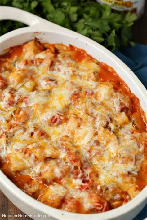 A Casserole Dish With Meat And Cheese In It On A Blue Towel Next To Parsley