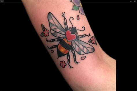 A Tattoo With A Bee And Hearts On It