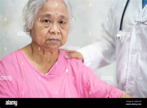 Asian Doctor Touching Asian Senior Or Elderly Old Lady Woman Patient
