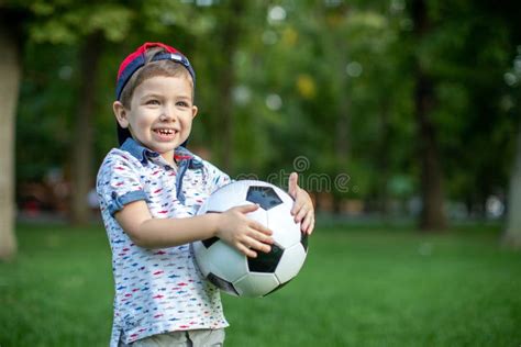 Little Child Hand Holding Football And Playing Soccer Ball Stock Image