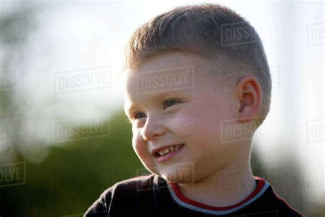Portrait Of Boy Smiling Outdoors Stock Photo Dissolve