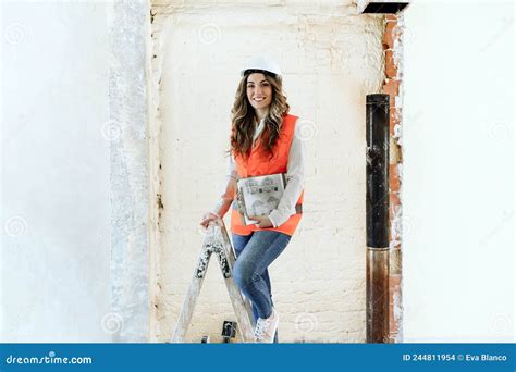 professional confident architect woman in construction site standing on ladder home renovation