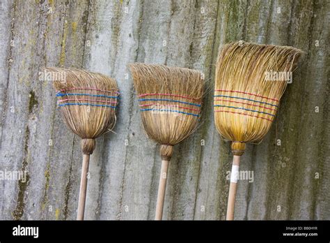 Three Used Brooms On A Concrete Wall Stock Photo Alamy