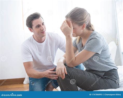 Young Caucasian Man Comforting Sad Woman And Sit On Begin Bedroom Stock