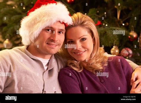 Couple Relaxing In Front Of Christmas Tree Stock Photo Alamy