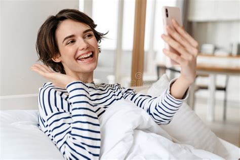 Happy Girl Taking Selfie On Mobile Phone While Lying In Bed Stock Image Image Of Selfie