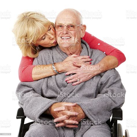 Woman Hugging A Senior Man In Wheelchair Isolated Stock Photo