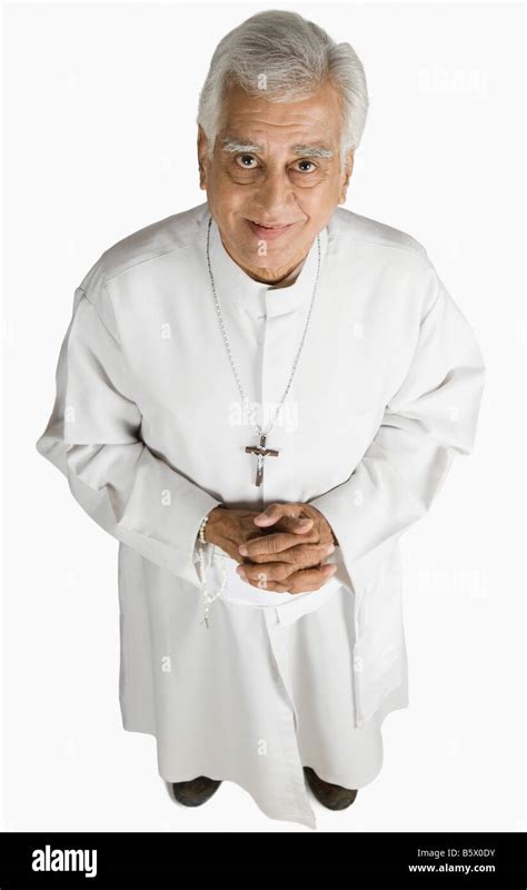 Portrait Of A Priest Standing With Hands Clasped And Smiling Stock