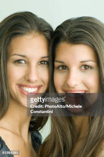 Two Twin Teenage Sisters Smiling At Camera Cheek To Cheek Portrait High
