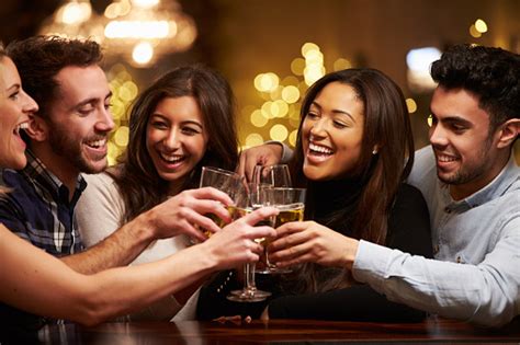 Group Of Friends Enjoying Evening Drinks In Bar Stock Photo Download