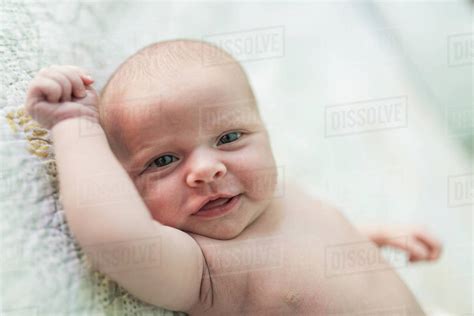 Portrait Of Shirtless Smiling Baby Girl Lying On Bed At Home Stock Photo Dissolve