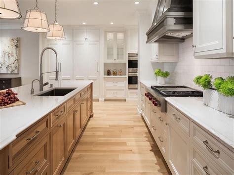 Two Toned Kitchen Island Featuring Oak Cabinetry And White Marble Countertops With A Beveled
