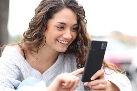 Happy Woman Using Smart Phone Sitting In The Street Stock Photo Image