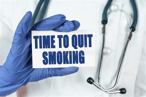 The Doctor Holds A Business Card That Says Time To Quit Smoking Stock