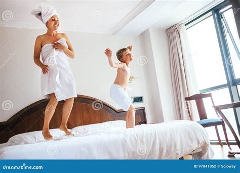 Mother And Son Jump On Bed In Luxury Hotel Room Stock Photo Image Of Bedroom Mattress