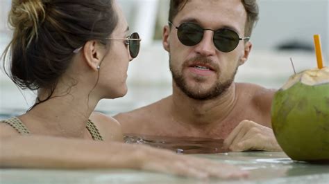 Medium Shot Of Affectionate Couple In Sunglasses Relaxing In Swimming Pool Kissing And Talking