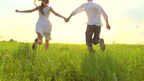 Happy Young Couple Holding Hands Run Through A Royalty Free Video