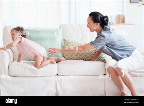 Niña Con Madre Jugando En Sofa Fotografías E Imágenes De Alta