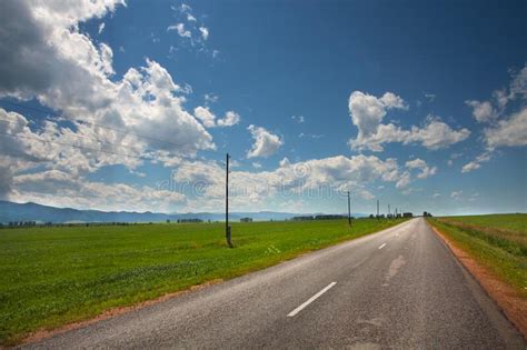 Road Among Fields Goes Into The Beautiful Sky Rural Stock Photo