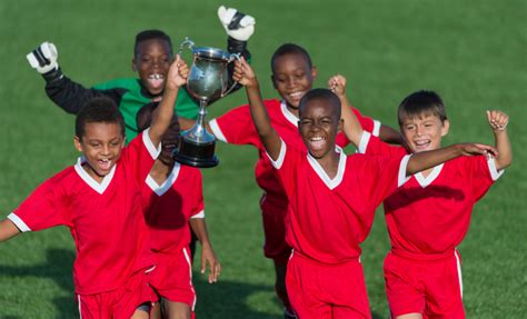 A Kids Soccer Team Celebrating With A Trophy Innerlink