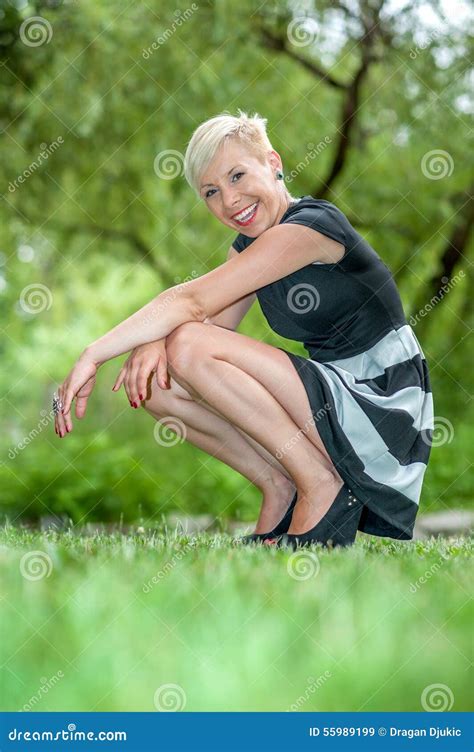 attractive blonde girl posing in nature crouching stock image image of smiling slim 55989199