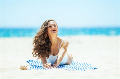 Smiling Woman On Ocean Shore Lying On Striped Towel Enjoying Stock Image Image Of Woman