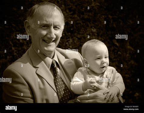 Grandfather Holding His Grandson Portrait In Garden Stock Photo Alamy