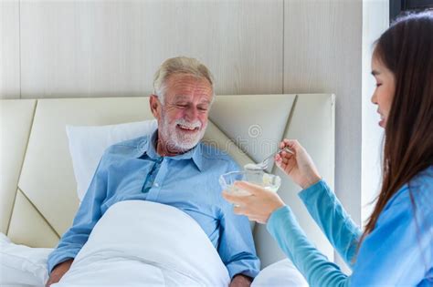 caregiver nurse take care a senior patient sit on wheelchair nurse helping senior man stock