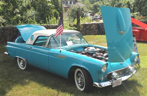 An Old Blue Car With The Hood Open And American Flag On Its Hood