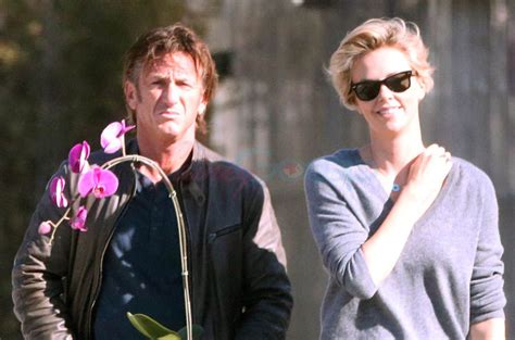 charlize theron and sean penn holding hands smiling and