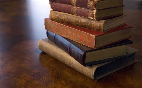 A stack of old books on a wooden surface wallpapers and images ...