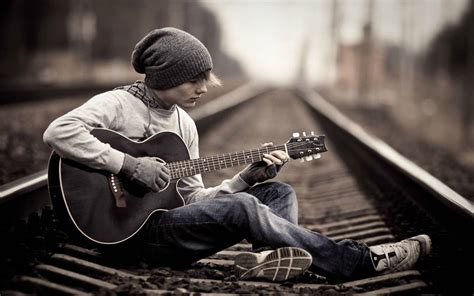 Download Teenage Boy Standing Alone On A Railway Track Wallpaper