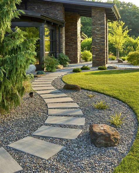 A Stone Path In The Middle Of A Garden With Rocks And Grass Around It