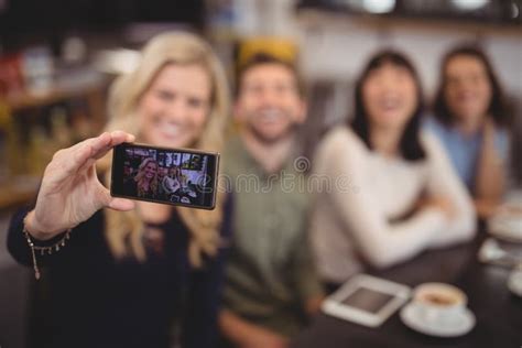 Woman Taking Selfie With Friends From Mobile Phone At Coffee Shop Stock Image Image Of Holding