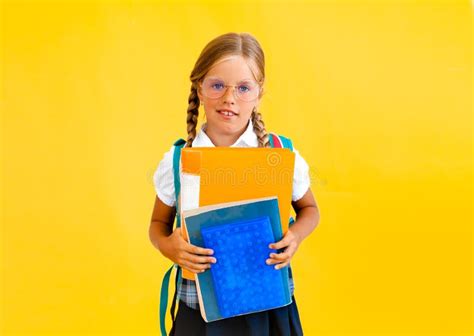 Portrait Of A Smiling Little Schoolgirl With Backpack Holding Notebook