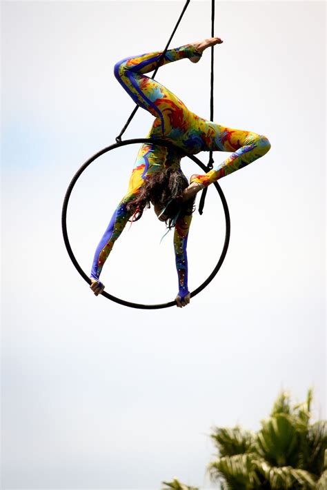 lyra aerialist in a funky cool jumpsuit costume performing an inverted stag pose in a double