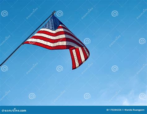 A Close Up Of An American Flag Blowing On A Flagpole Stock Photo