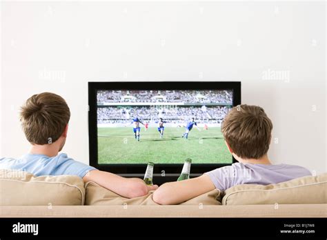 Two Young Men Watching Football On The Tv Stock Photo Alamy