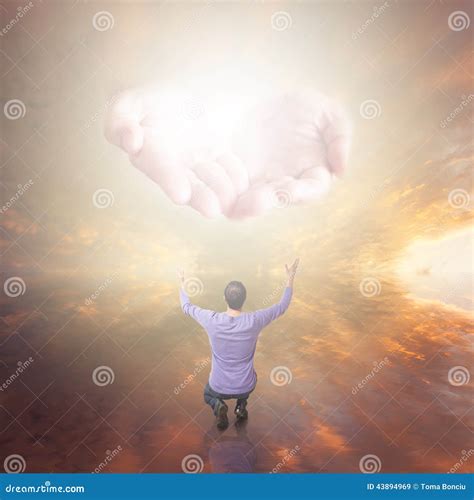 Man Worshiping God Hands With Light Coming From The Sky Stock Photo