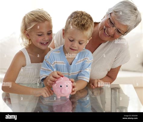 Grandmother And Children Saving Money In A Piggybank Stock Photo Alamy