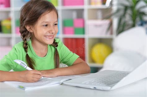 Portrait Of Concentrated Little Girl With Laptop Studying Stock Image
