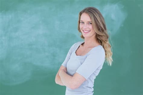 premium photo smiling teacher standing in front of blackboard