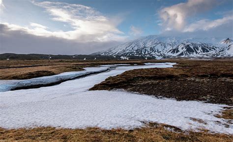 Icelandic Landscape With Mountains And Meadow Land Covered In Snow