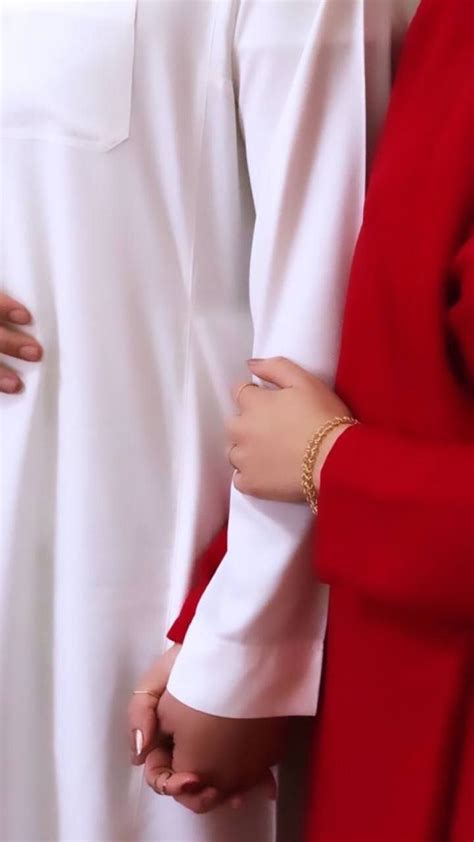 Two People Standing Next To Each Other Wearing Red And White Robes One