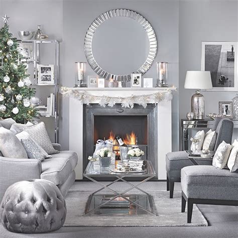 On either side of the mirror, wall sconces hold pillar candles. Silver and grey Christmas living room | Decorating ...