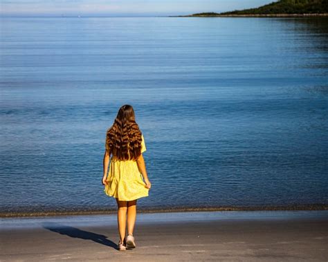 Premium Photo Beautiful Girl In A Yellow Dress Stares At The Sea On A