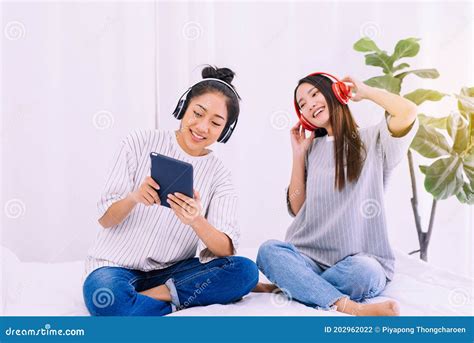 Beautiful Asian Lesbian Couple Listening To Music Together At Home Lgbt