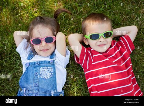 Sweel Little Boy And Girl Wearing Glasses Smiling Laying On The