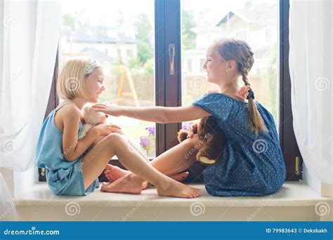 Two Cute Girls Playing Toys On Sill Near Window At House Stock Image