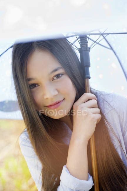 Portrait Of Happy Teenage Girl Holding Umbrella Outdoors — Looking At